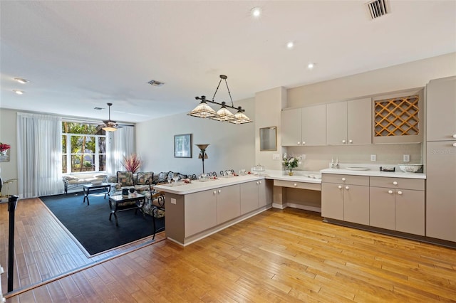 kitchen featuring light hardwood / wood-style flooring, gray cabinets, kitchen peninsula, pendant lighting, and ceiling fan