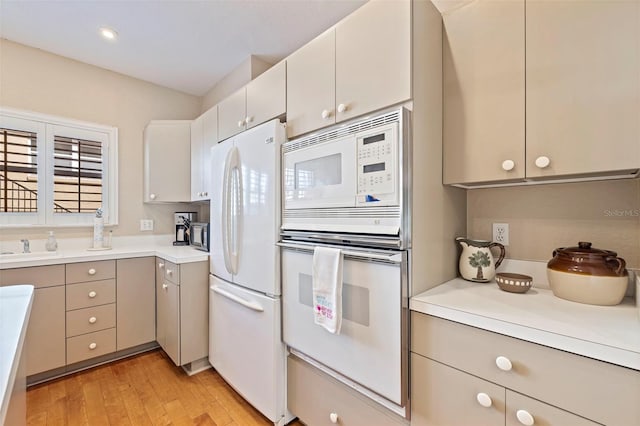 kitchen with white appliances and light hardwood / wood-style flooring