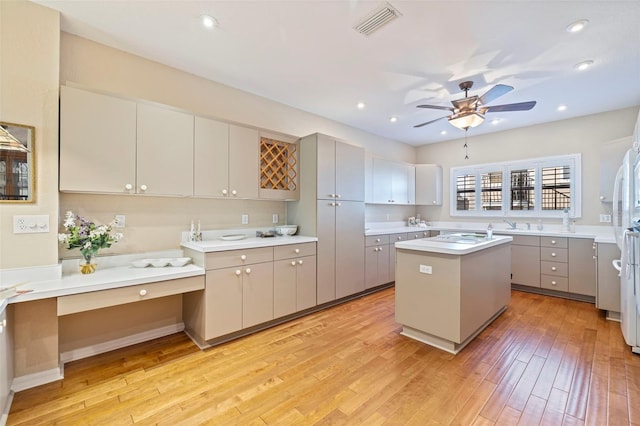 kitchen with ceiling fan, light wood-type flooring, a kitchen island, and gray cabinetry