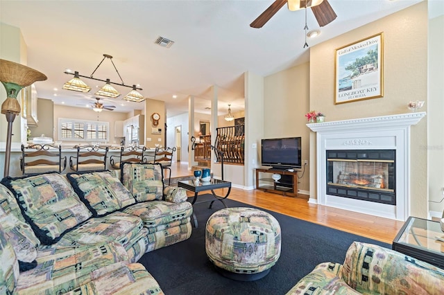 living room with light hardwood / wood-style flooring and ceiling fan