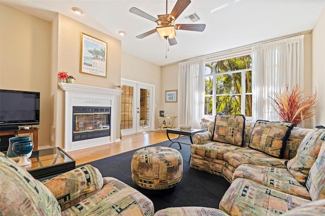 living room featuring french doors, ceiling fan, and light hardwood / wood-style floors