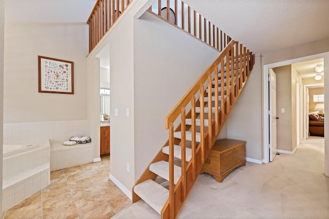 staircase featuring a textured ceiling