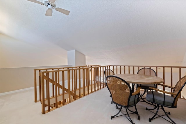 interior space featuring light carpet, ceiling fan, lofted ceiling, and a textured ceiling