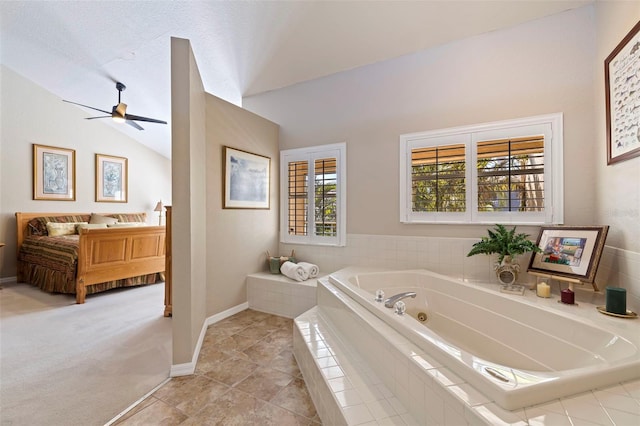 bathroom with ceiling fan, lofted ceiling, tile patterned floors, and tiled tub