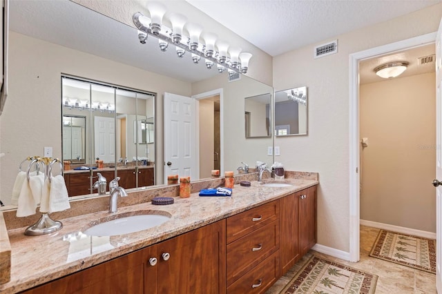 bathroom featuring tile patterned floors, vanity, and a textured ceiling