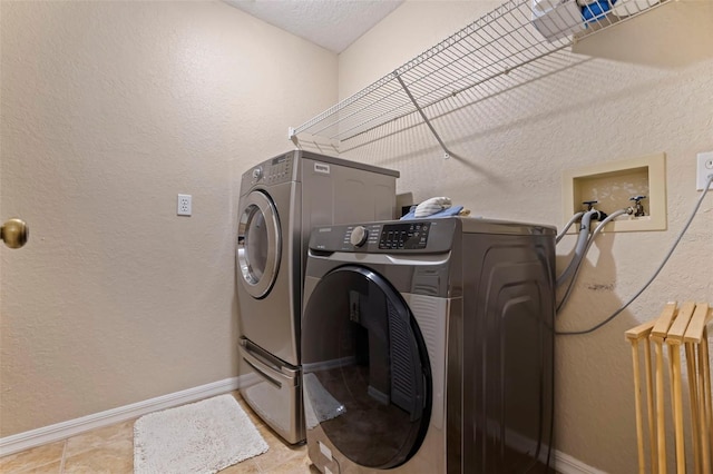 laundry area featuring radiator heating unit, washing machine and clothes dryer, and a textured ceiling