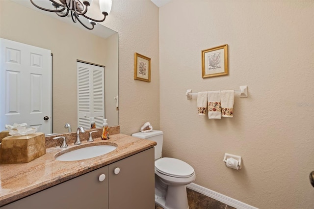 bathroom featuring vanity, a chandelier, and toilet