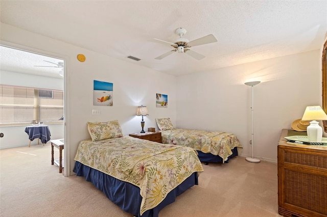 carpeted bedroom with ceiling fan and a textured ceiling