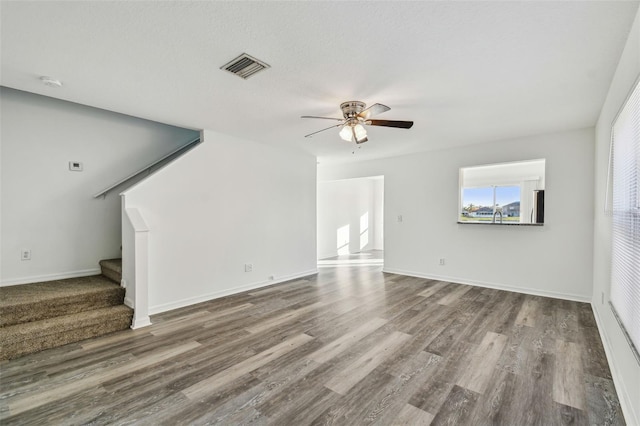 unfurnished living room with ceiling fan and wood-type flooring