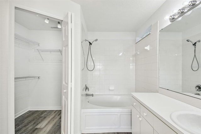 bathroom with vanity, hardwood / wood-style floors, and tiled shower / bath