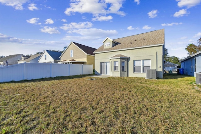 back of property with a yard and central air condition unit