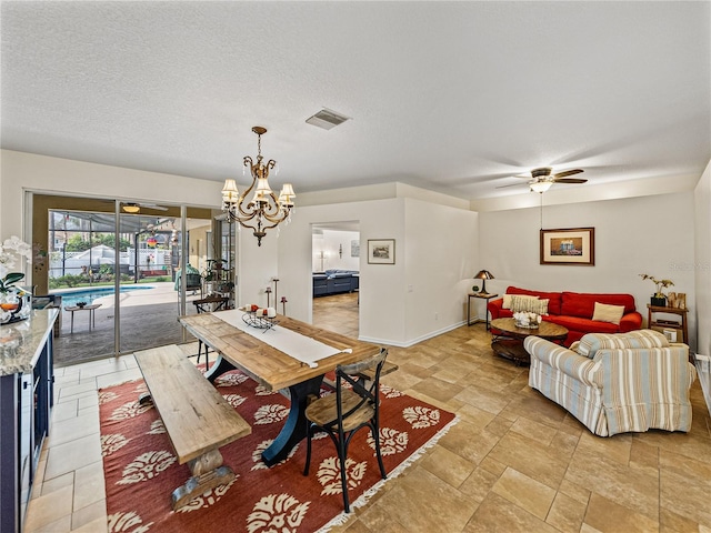 dining room featuring ceiling fan with notable chandelier and a textured ceiling