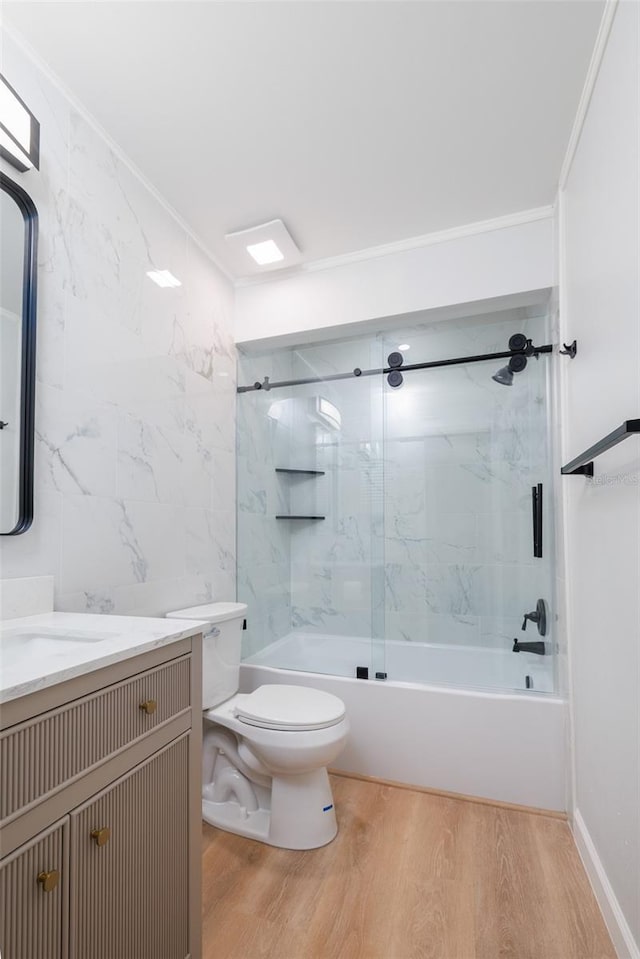 full bathroom featuring tile walls, vanity, wood-type flooring, tiled shower / bath, and toilet