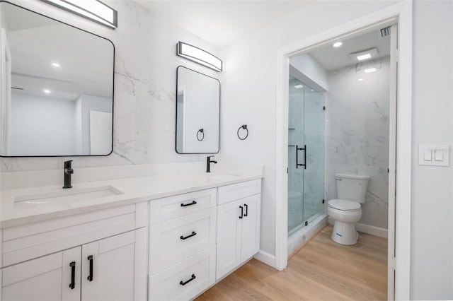 bathroom featuring vanity, toilet, a shower with door, and hardwood / wood-style floors