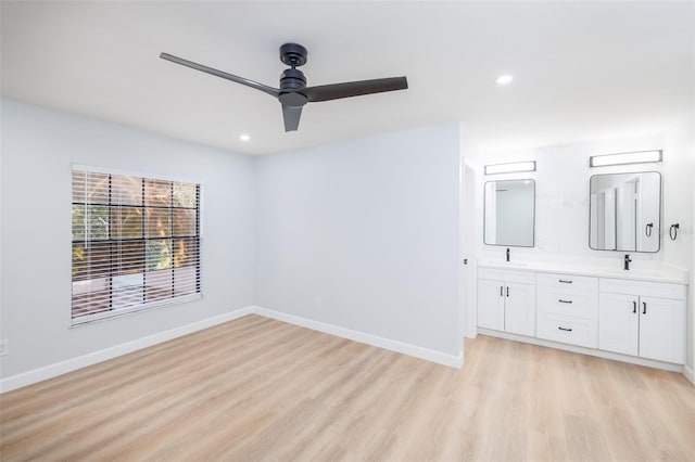 unfurnished bedroom with sink, ceiling fan, and light wood-type flooring