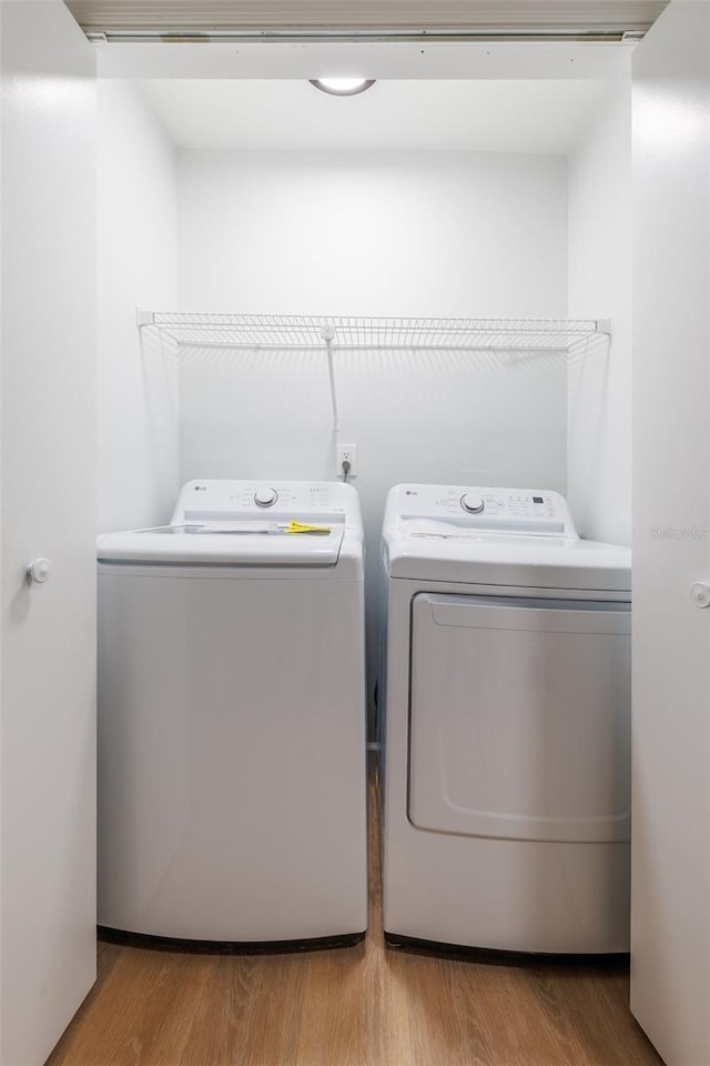 laundry room featuring hardwood / wood-style flooring and separate washer and dryer