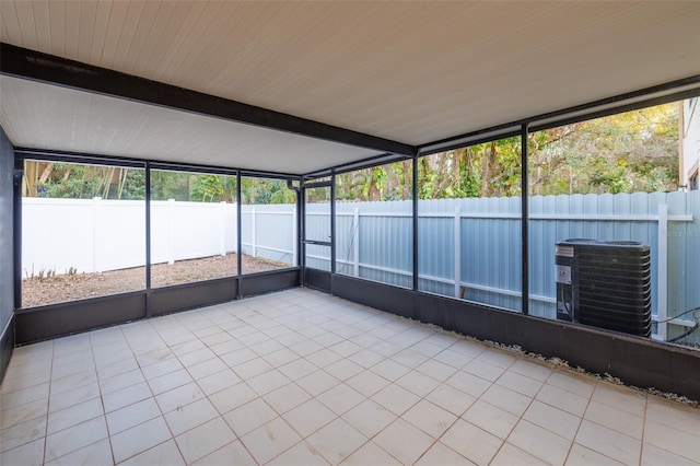 unfurnished sunroom with beam ceiling