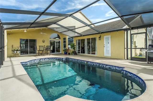 view of pool featuring a patio, ceiling fan, and glass enclosure