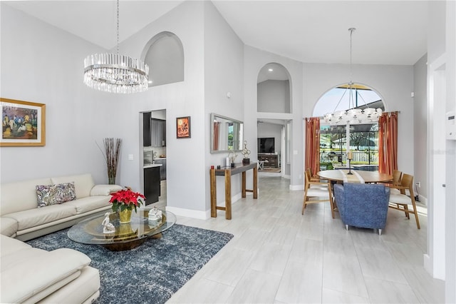 living room featuring a notable chandelier and high vaulted ceiling