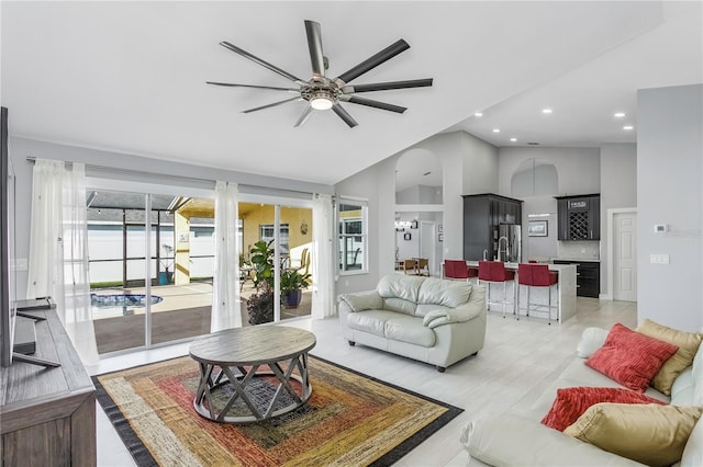 living room with ceiling fan and high vaulted ceiling