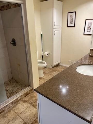 bathroom with vanity, an enclosed shower, and toilet