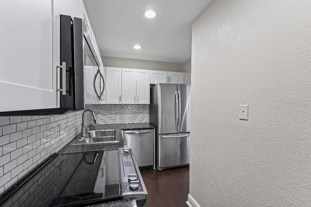 kitchen with sink, stainless steel appliances, white cabinets, dark hardwood / wood-style flooring, and decorative backsplash