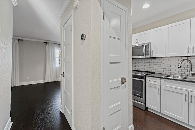 kitchen featuring sink, tasteful backsplash, appliances with stainless steel finishes, dark hardwood / wood-style floors, and white cabinets