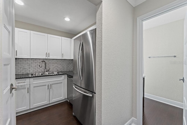 kitchen with appliances with stainless steel finishes, sink, white cabinets, and dark hardwood / wood-style floors