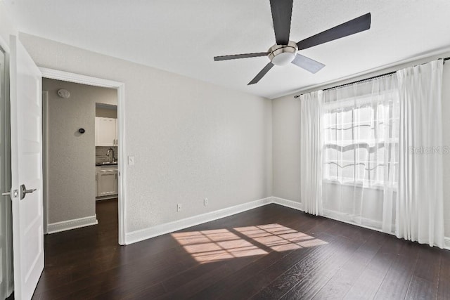 empty room featuring ceiling fan, dark hardwood / wood-style flooring, and sink