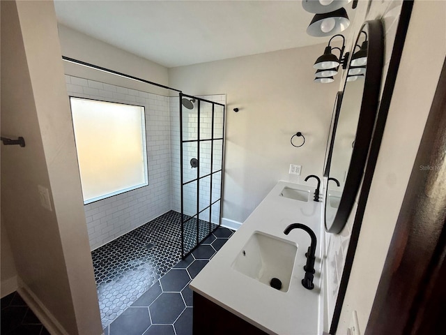 bathroom featuring tiled shower, vanity, and tile patterned floors