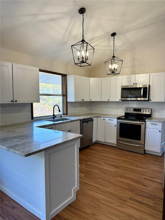 kitchen with white cabinetry, decorative light fixtures, kitchen peninsula, and appliances with stainless steel finishes