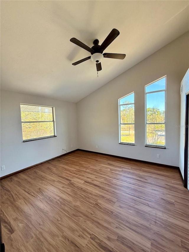 unfurnished room with light hardwood / wood-style flooring, vaulted ceiling, and ceiling fan