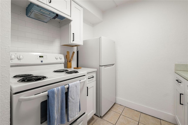 kitchen with tasteful backsplash, white cabinets, custom exhaust hood, light tile patterned floors, and white appliances