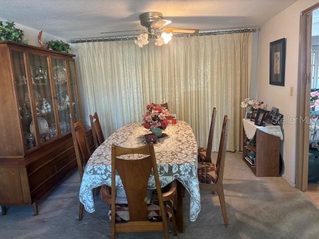 dining area featuring ceiling fan and carpet