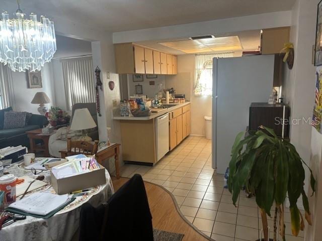 kitchen with a chandelier, refrigerator, light tile patterned floors, dishwasher, and a healthy amount of sunlight