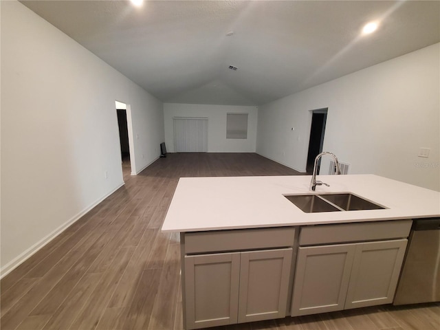 kitchen featuring sink, gray cabinets, stainless steel dishwasher, and hardwood / wood-style floors