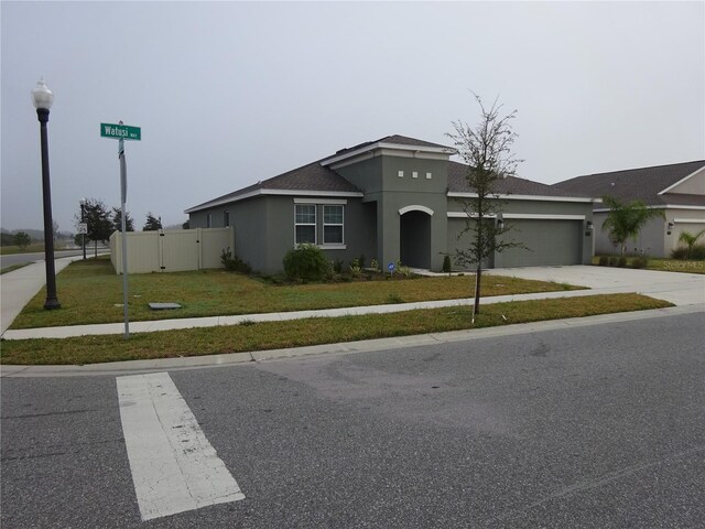 view of front of property with a garage and a front lawn