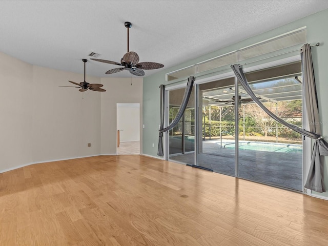 spare room featuring ceiling fan, a textured ceiling, and light wood-type flooring