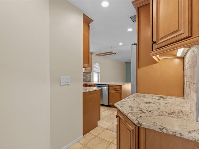 kitchen featuring dishwasher, light tile patterned flooring, light stone counters, and decorative backsplash