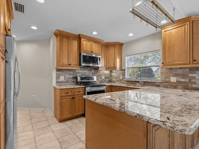 kitchen featuring tasteful backsplash, sink, light tile patterned floors, light stone counters, and stainless steel appliances