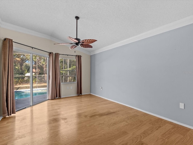 empty room with lofted ceiling, ceiling fan, light hardwood / wood-style floors, crown molding, and a textured ceiling