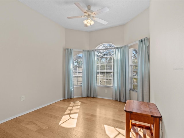 interior space with a textured ceiling, light hardwood / wood-style floors, and ceiling fan