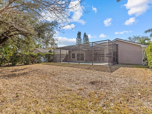 rear view of house with a lanai, a swimming pool, and a patio