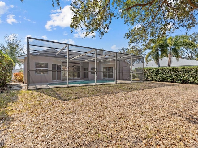 back of house with a fenced in pool, a lawn, and glass enclosure