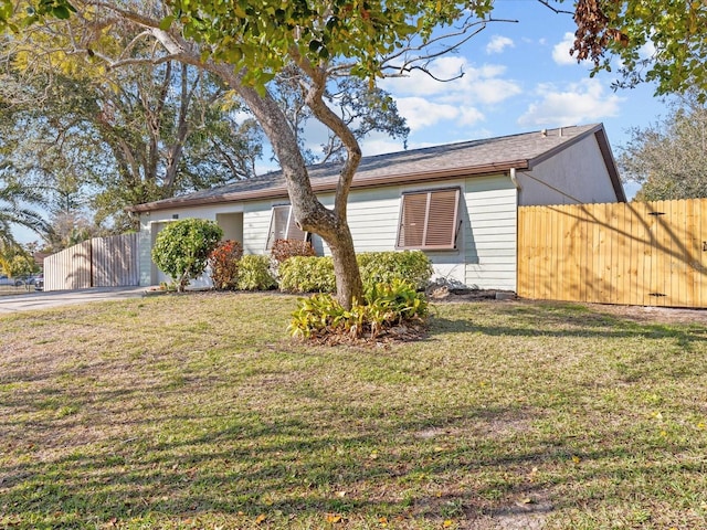 view of front of property featuring a garage, a front lawn, and fence