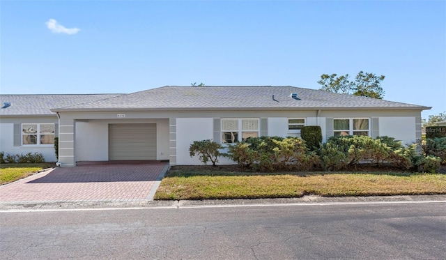 ranch-style house with a garage and a front lawn