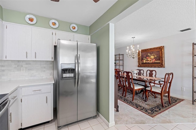 kitchen featuring light tile patterned floors, white cabinetry, hanging light fixtures, stainless steel refrigerator with ice dispenser, and decorative backsplash