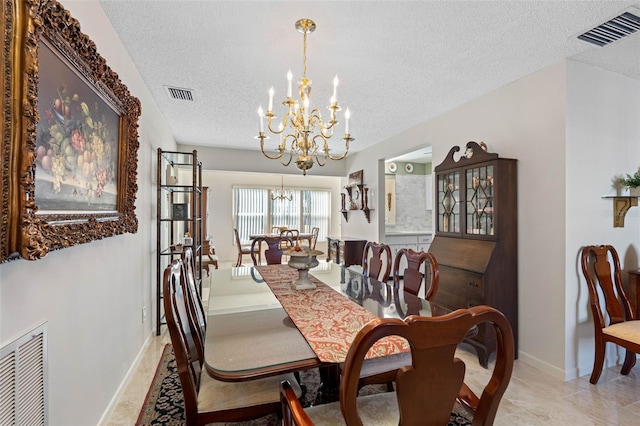 dining space featuring a chandelier and a textured ceiling