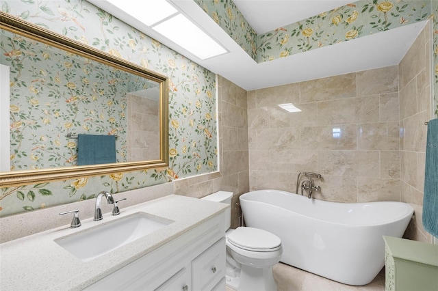 bathroom featuring vanity, a washtub, and toilet