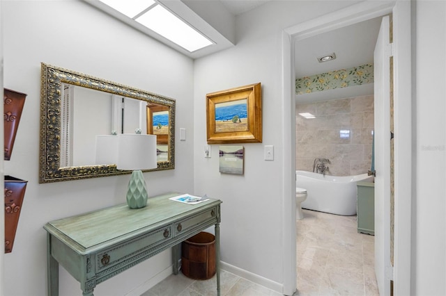 bathroom with a washtub and toilet